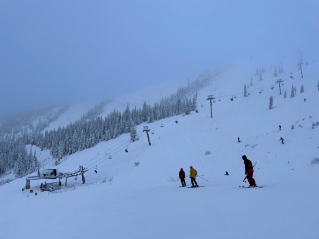 Ski slope in winter. A lift in the middle distance is heading up and to the right.