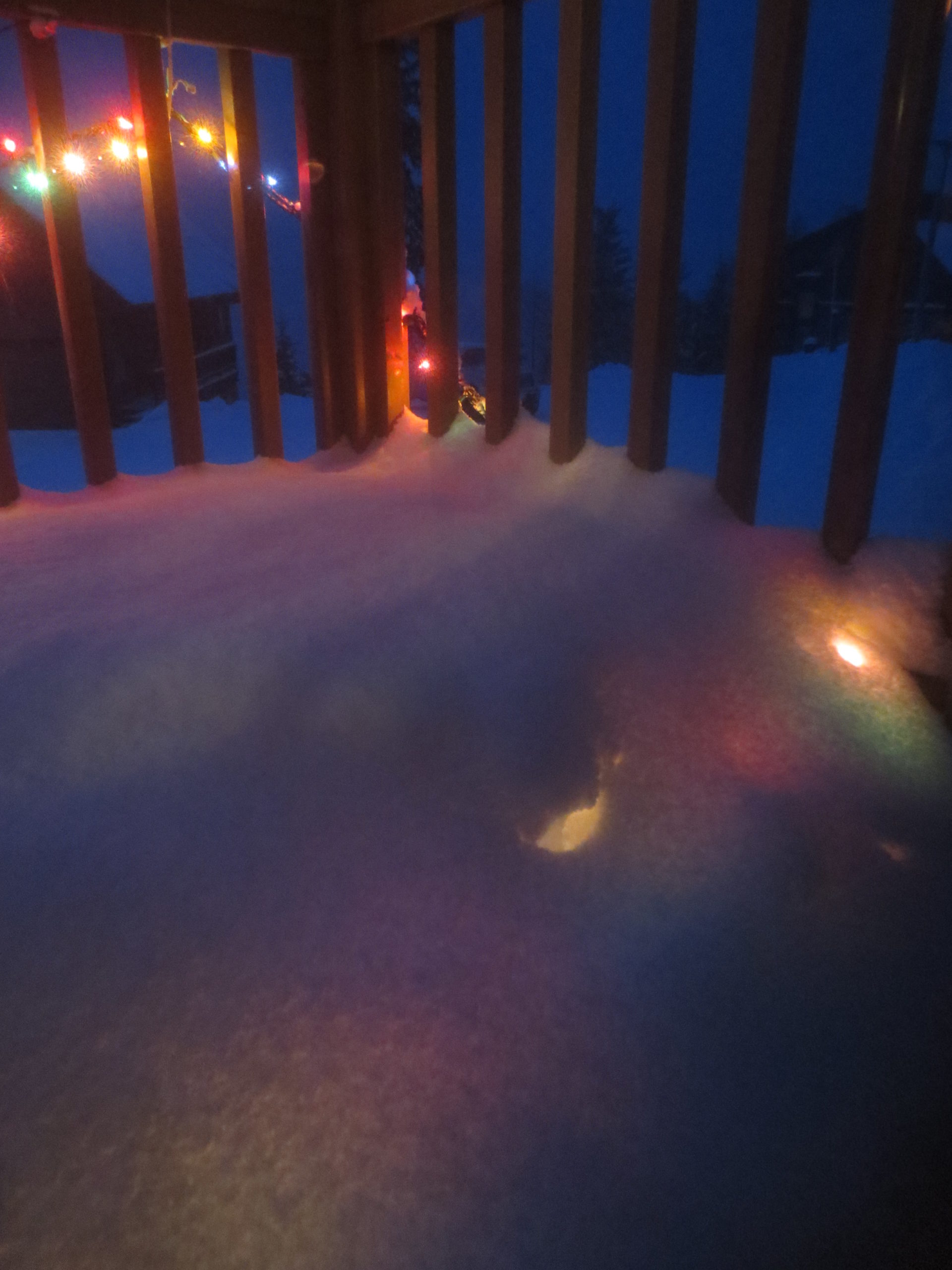 snow with glow of Christmas lights underneath